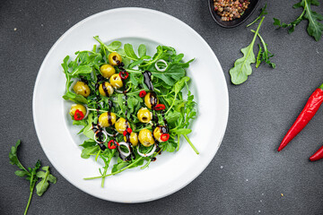 salad olives, hot chili peppers, green mix lettuce, arugula healthy meal food snack on the table copy space food background rustic top view keto or paleo diet veggie vegan or vegetarian food