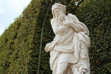 statue of the winter in the gardens of the castle of versailles (france)