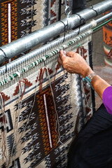 Cameron, Arizona: A Navajo woman demonstrates traditional rug weaving at the Cameron Trading Post,  a Native American cultural center. - obrazy, fototapety, plakaty