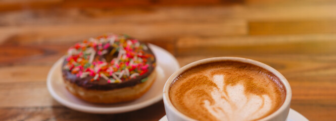 Cappuccino banner with donut on a wooden background. Stylish concept of drinks and sweets - obrazy, fototapety, plakaty