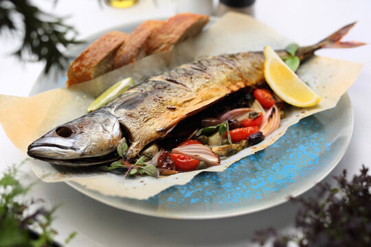 Whole, Baked Mackerel, Served With Vegetables And Bread, On A Plate. Roasted Fish On A Parchment Paper, Close-up.