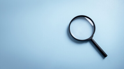 Top view empty lens black magnifying glass on white blue pastel background. Flat lay object and...
