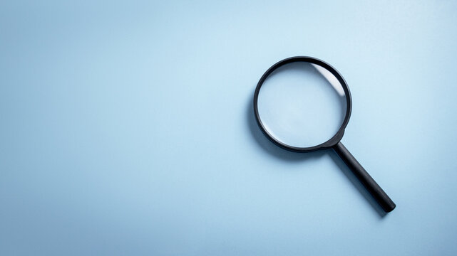 Top view empty lens black magnifying glass on white blue pastel background. Flat lay object and inspection investigate science equipment tool concept. Police and Ciencia forense theme. Copy space.