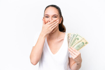 Young caucasian woman taking a lot of money isolated on white background happy and smiling covering mouth with hand