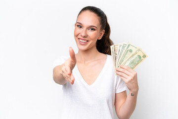Young caucasian woman taking a lot of money isolated on white background shaking hands for closing a good deal