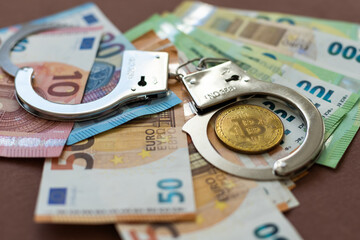handcuffs and a gun lying on the money - obrazy, fototapety, plakaty