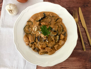 Italian art zucchini and aubergine al forno. Casserole with chicken, cream, tomatoes and parmesan.