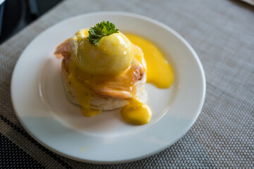 A delicious eggs benedict with salmon in white plate.