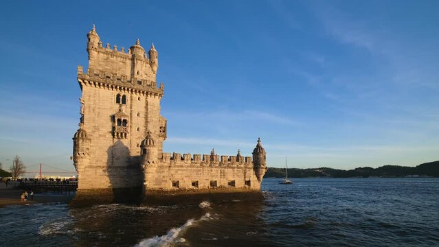 Belem Tower or Tower of St Vincent - famous tourist landmark of Lisboa and tourism attraction - on the bank of the Tagus River (Tejo) with tourist boats on sunset. Lisbon, Portugal