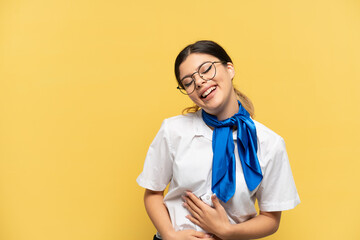 Airplane stewardess isolated on yellow background smiling a lot