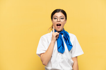 Airplane stewardess isolated on yellow background intending to realizes the solution while lifting a finger up