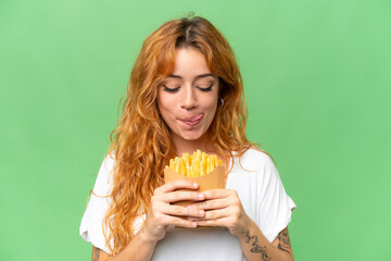 Young caucasian woman holding fried chips isolated on green screen chroma key background