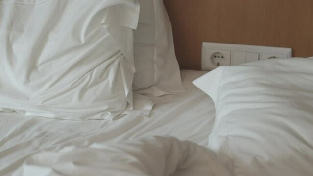 lit non fait avec des draps blancs. Lit vide non fait. Gros plan sur un drap de lit d&eacute;fait dans la chambre d'h&ocirc;tel apr&egrave;s une nuit de sommeil..