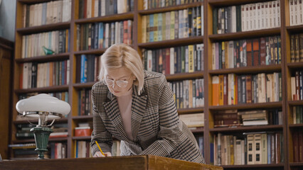 Female researcher working with historical archives in a library late at night