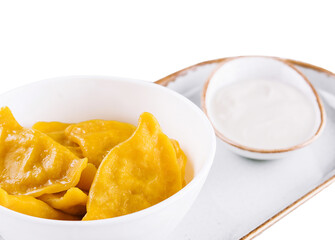 Tasty dumplings in bowl with sour cream