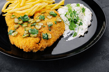 Delicious wiener hunter schnitzel with sauce and french fries close-up on a plate