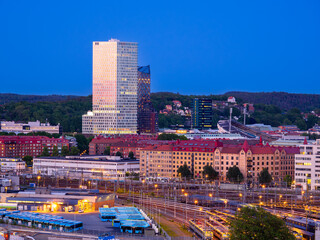 Gothenburg, Sweden - May 30, 2023: Blue hour in the industrial Scandinavian city of Gothenburg, Sweden, with skyscrapers residential apartment buildings, bus and railway station.