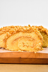 Three Slices of Peanut Roll Cake with Rhum on the Wood Board