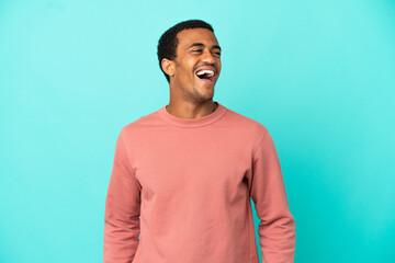 African American handsome man on isolated blue background laughing