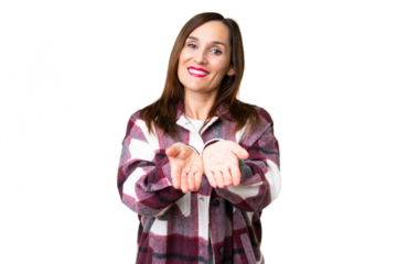 Middle age woman over isolated chroma key background holding copyspace imaginary on the palm to insert an ad