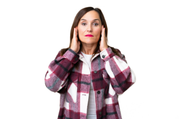 Middle age woman over isolated chroma key background frustrated and covering ears