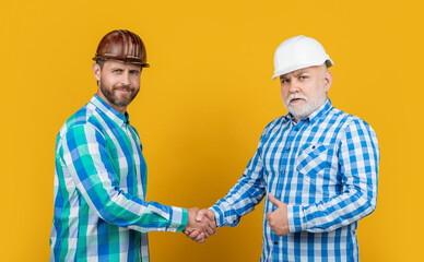 partners men handshaking wear building helmet. partners men handshaking