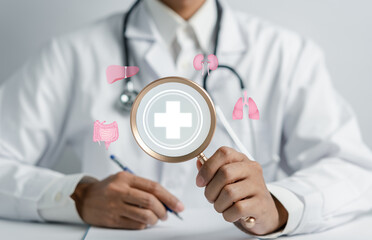 Doctor holding magnifier to examine internal organ for treatment and health care with plus signs...