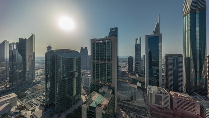 Fototapeta na wymiar Dubai international financial center skyscrapers with cloudy blue sky aerial all day timelapse.