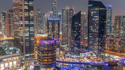 Dubai Marina Skyline with JLT district skyscrapers on a background aerial day to night timelapse.