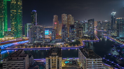 Fototapeta na wymiar Panorama showing Dubai Marina skyscrapers and JBR district with luxury buildings and resorts aerial night timelapse