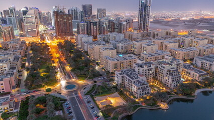 Skyscrapers in Barsha Heights district and low rise buildings in Greens district aerial day to night timelapse.