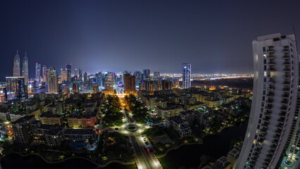 Panorama with skyscrapers in Barsha Heights district and low rise buildings in Greens district aerial all night timelapse.