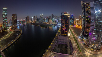 Cityscape panorama of skyscrapers in Dubai Business Bay with water canal aerial day to night timelapse