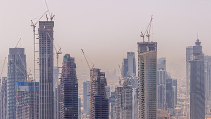 Fototapeta na wymiar Dubai downtown with large-scale construction of a residential complex with a view of construction cranes aerial timelapse