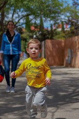 boy with yellow shirt leaving school running looking at the camera