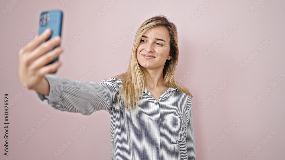 Sticker young blonde woman smiling confident making selfie by the smartphone over isolated pink background