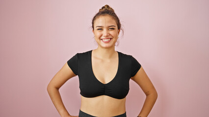 Fototapeta premium Young beautiful hispanic woman wearing sportswear smiling over isolated pink background