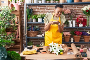 African american woman florist make photo to flowers by smartphone at florist
