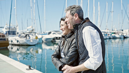 Fototapeta premium Senior man and woman couple smiling confident hugging each other at port