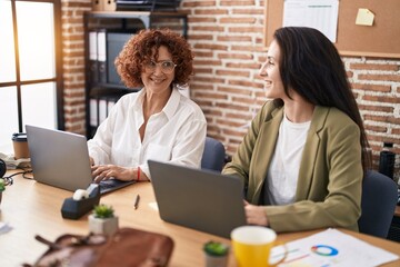 Two women business workers using laptop working at office