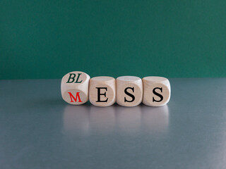 Bless mess symbol. Turned the cube and changes the red word 'mess' to 'bless'. Beautiful grey table, green background, copy space. Business and bless mess concept.