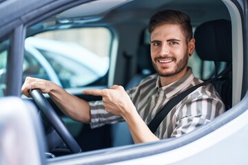 Hispanic man with beard driving car smiling happy pointing with hand and finger