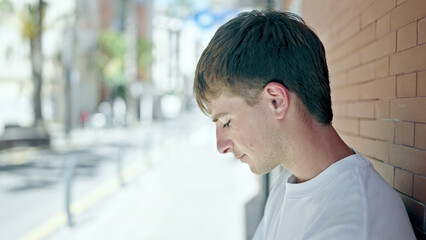 Young caucasian man looking to the side with serious expression at street