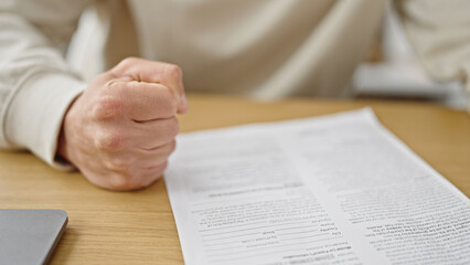 Naklejka premium Young caucasian man with angry expression sitting on table at dinning room