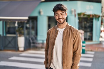 Fototapeta premium Young hispanic man smiling confident standing at street