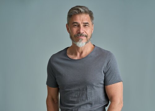 Portrait of happy casual older bearded man with gray hair smiling, Mid adult, mature age guy standing, isolated on gray background.