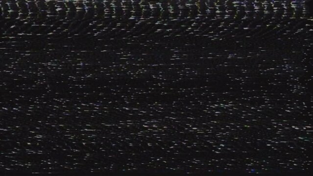Interference and image distortion on old VHS film. The end of an old film recorded on a video cassette. Black screen with artifacts and bad image flicker.