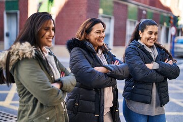 Three woman mother and daughters standing with arms crossed gesture at street