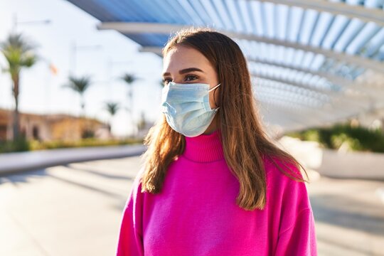 Young woman wearing medical mask at park - Powered by Adobe