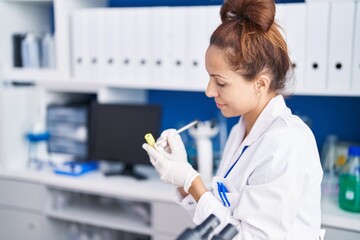 Young woman scientist writing on urine test tube at laboratory